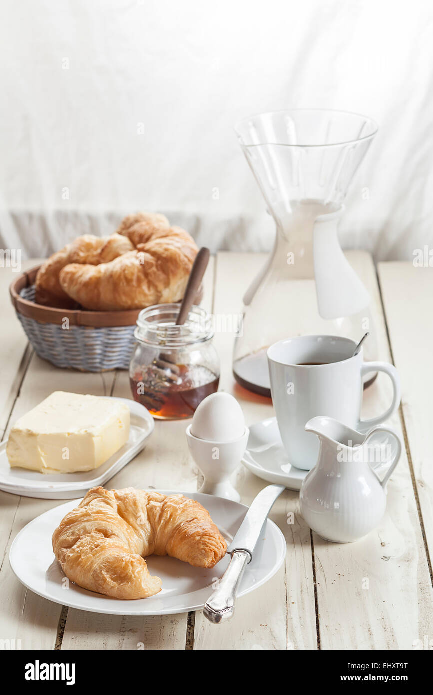 Frühstück mit Croissant, Ei, Kaffee, Honig und butter Stockfoto