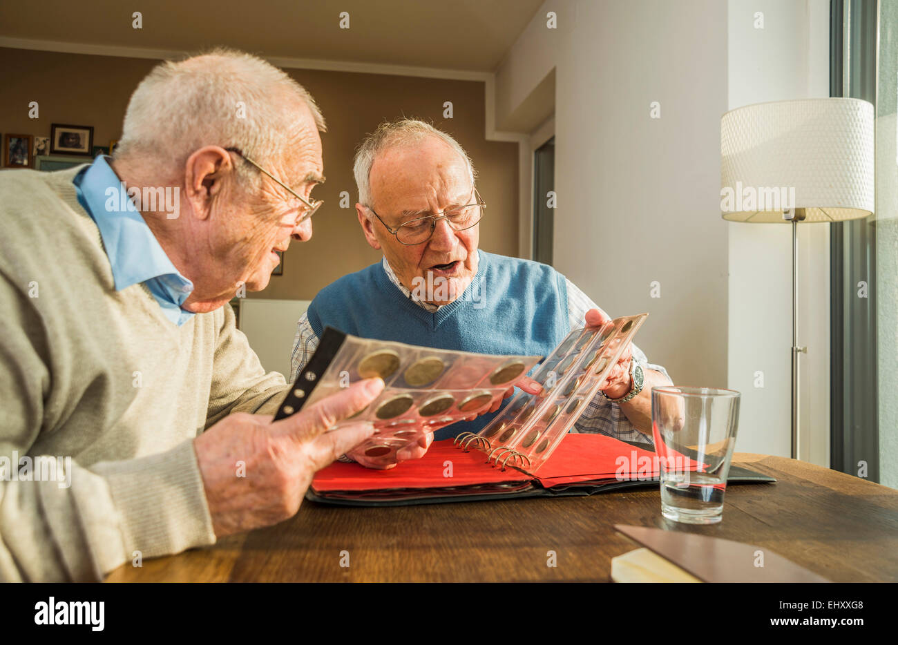 Zwei Senioren Freunde mit Münzenalbum Stockfoto