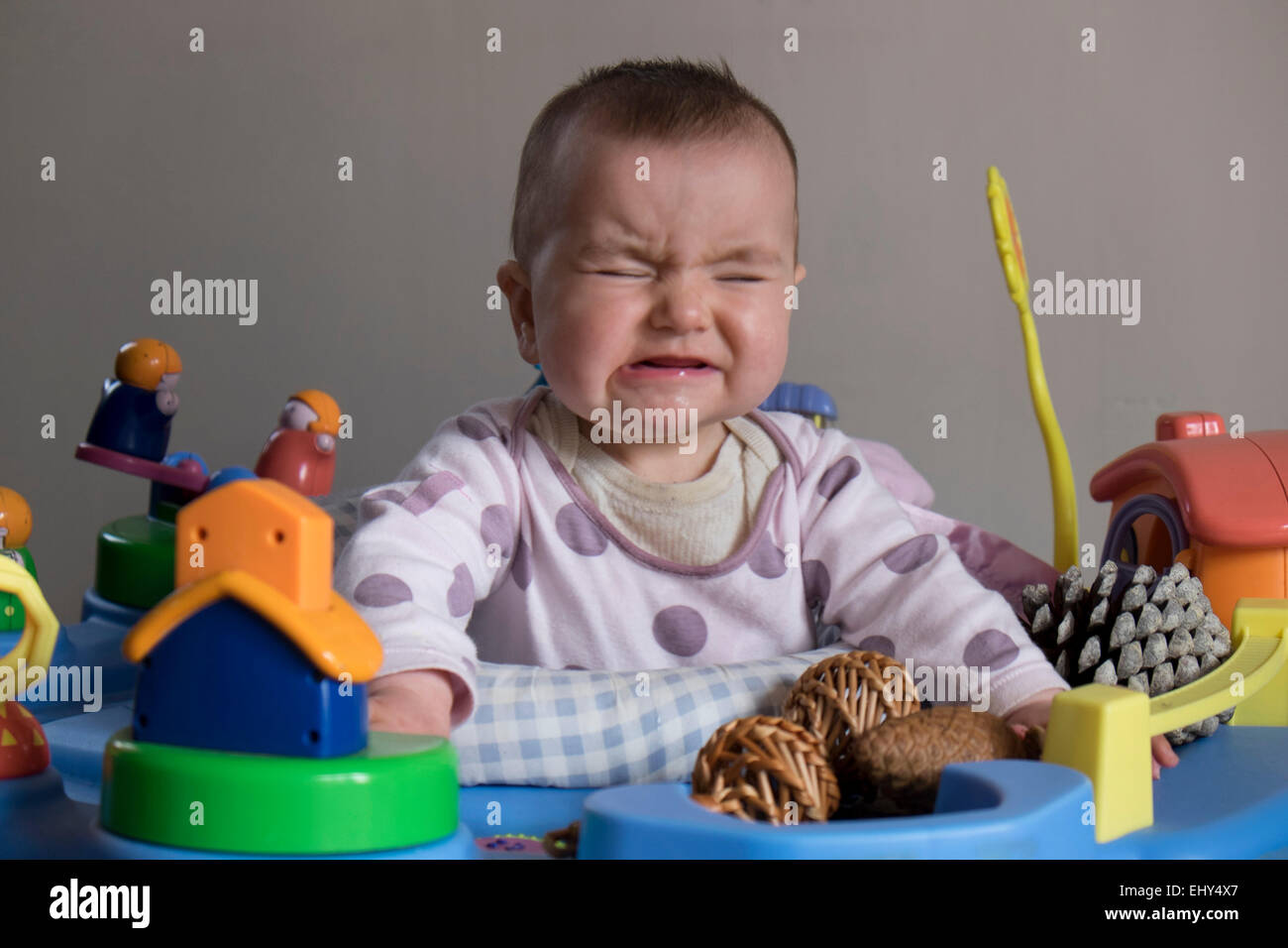 8 Monate altes Baby Mädchen in Babywippe Weinen Stockfoto