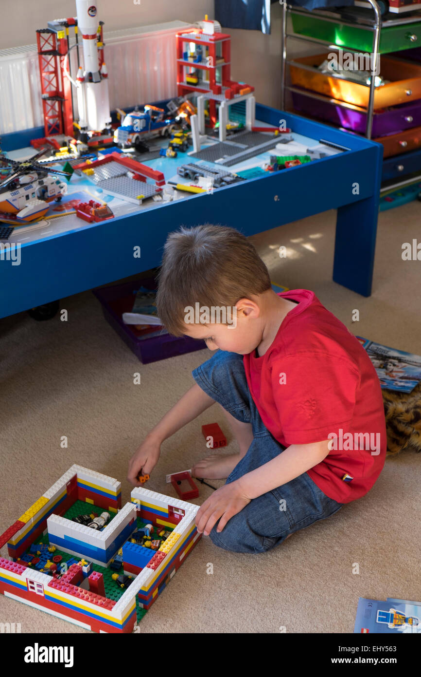 Jungen im Alter von vier Jahren spielen mit Lego-Bausteinen im Schlafzimmer Stockfoto