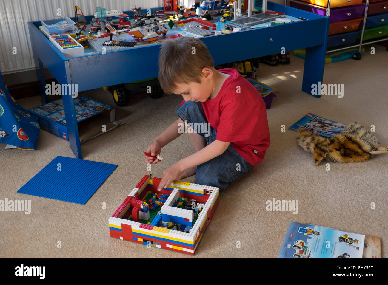 Jungen im Alter von vier Jahren spielen mit Lego-Bausteinen im Schlafzimmer Stockfoto