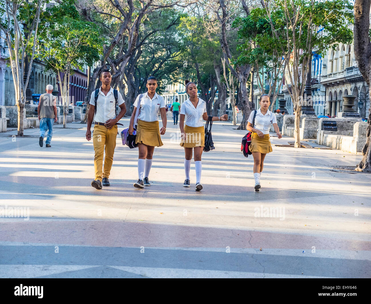 Vier Schüler der Sekundarstufe Havanna, drei Mädchen und ein Junge, gehen gemeinsam zur Schule in Havanna Vieja. Stockfoto