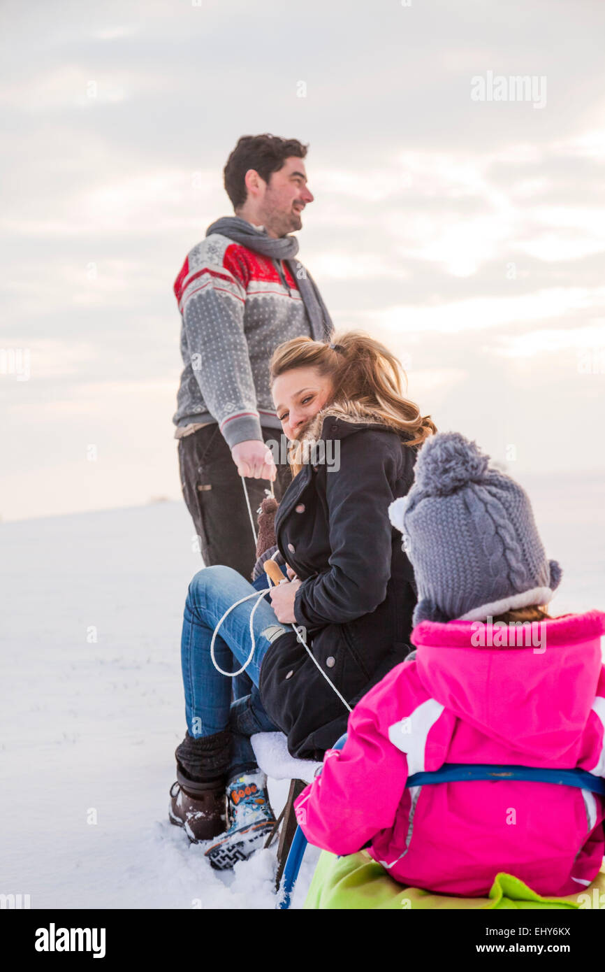 Glückliche Familie im Schnee Rodeln Stockfoto