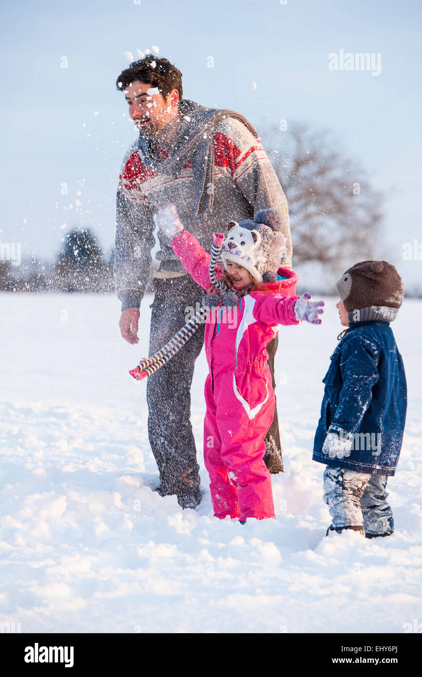 Vater mit Kindern in Schneelandschaft Stockfoto