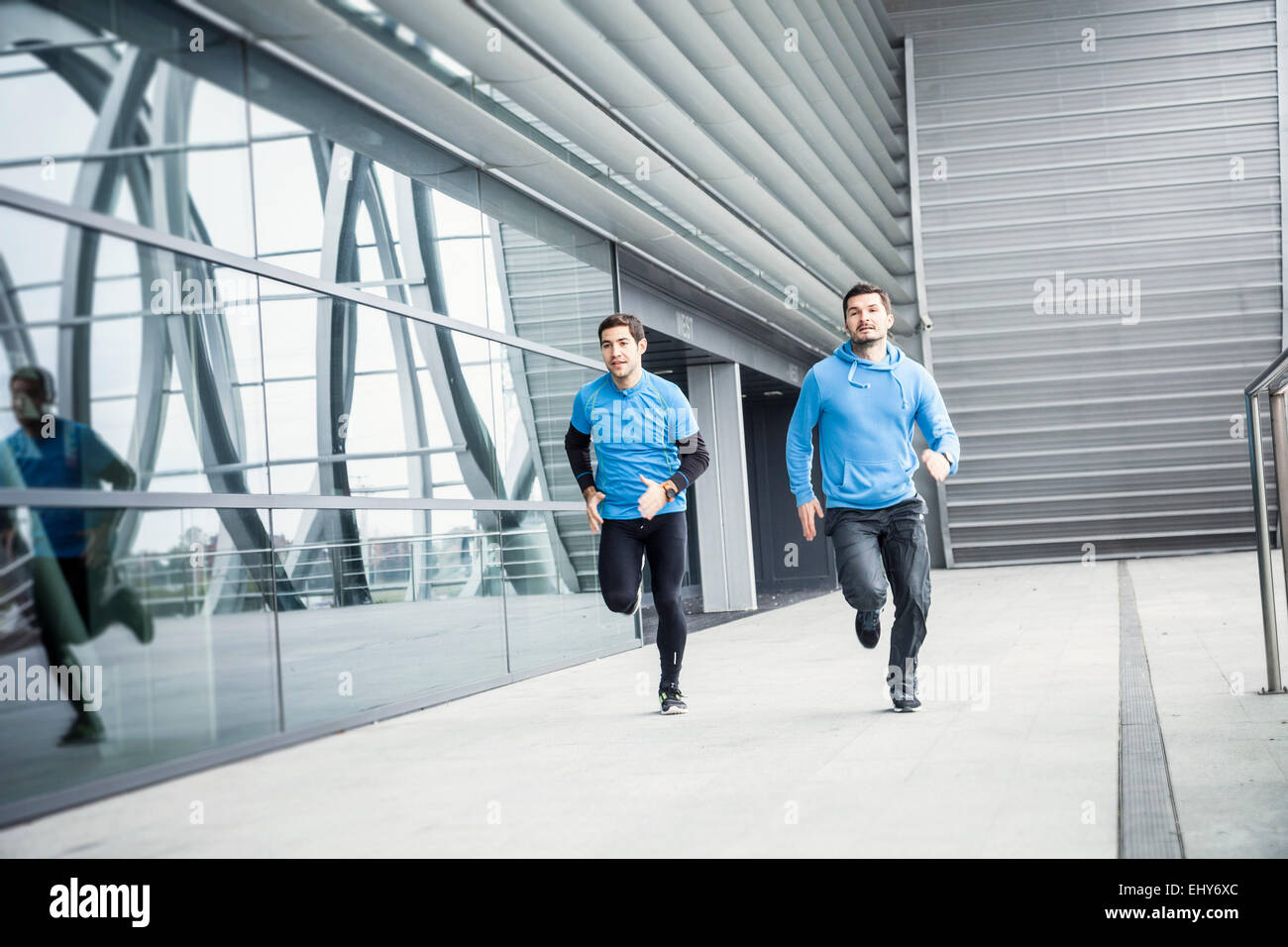 Zwei Männer sprinten nebeneinander in Stadt Stockfoto