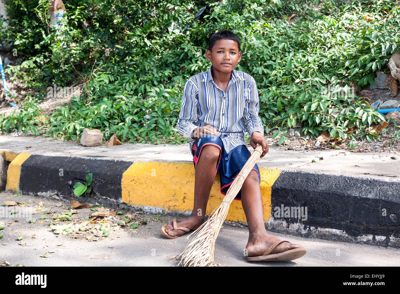 Kambodschanischen jungen posieren für Porträt, nachdem gefegt Straße mit Palmen Besen in Kep, Kambodscha verlassen. Stockfoto