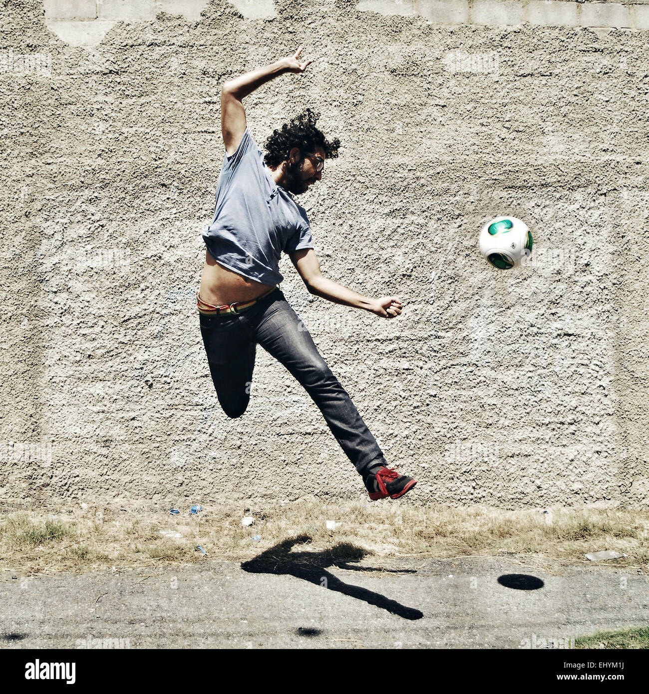 Mann auf der Straße Fußball zu spielen Stockfoto