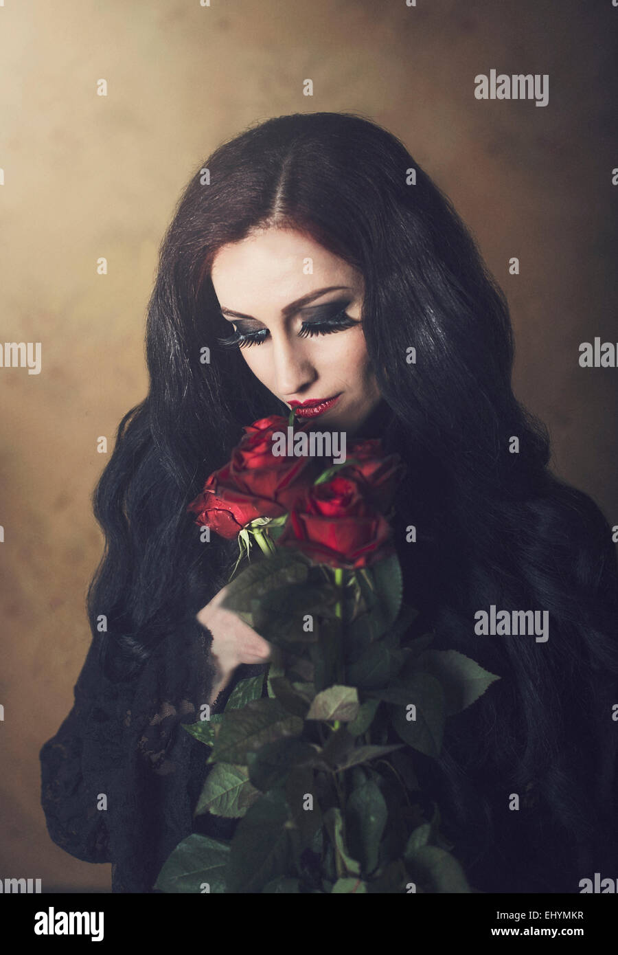 Porträt einer Frau in schwarzem Holding Strauß roter Rosen Stockfoto