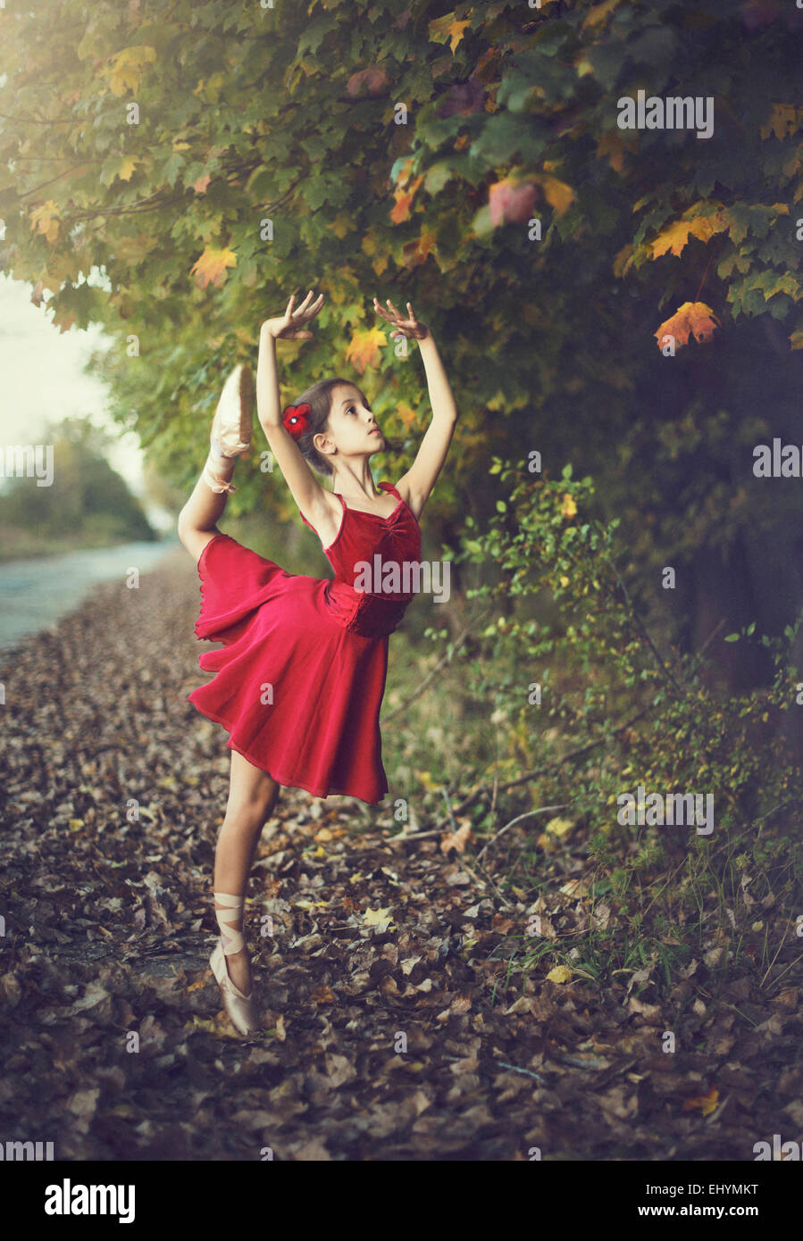 Mädchen tun Ballett im Freien im roten Kleid Stockfoto
