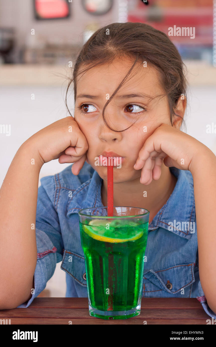 Mürrischen Mädchen Mocktail durch einen Strohhalm trinken Stockfoto