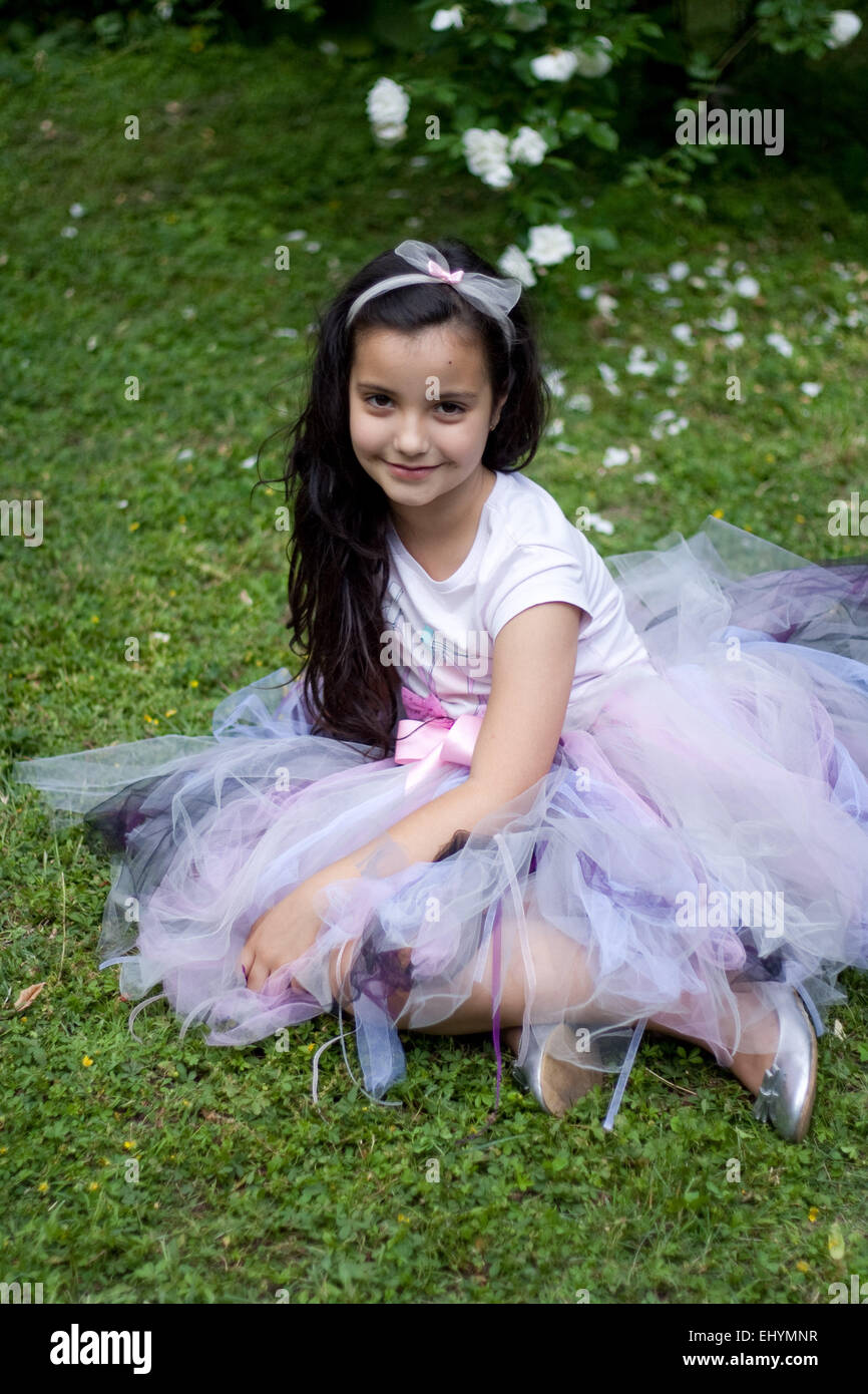 Mädchen, gekleidet in einem Tutu sitzen auf dem Rasen Stockfoto