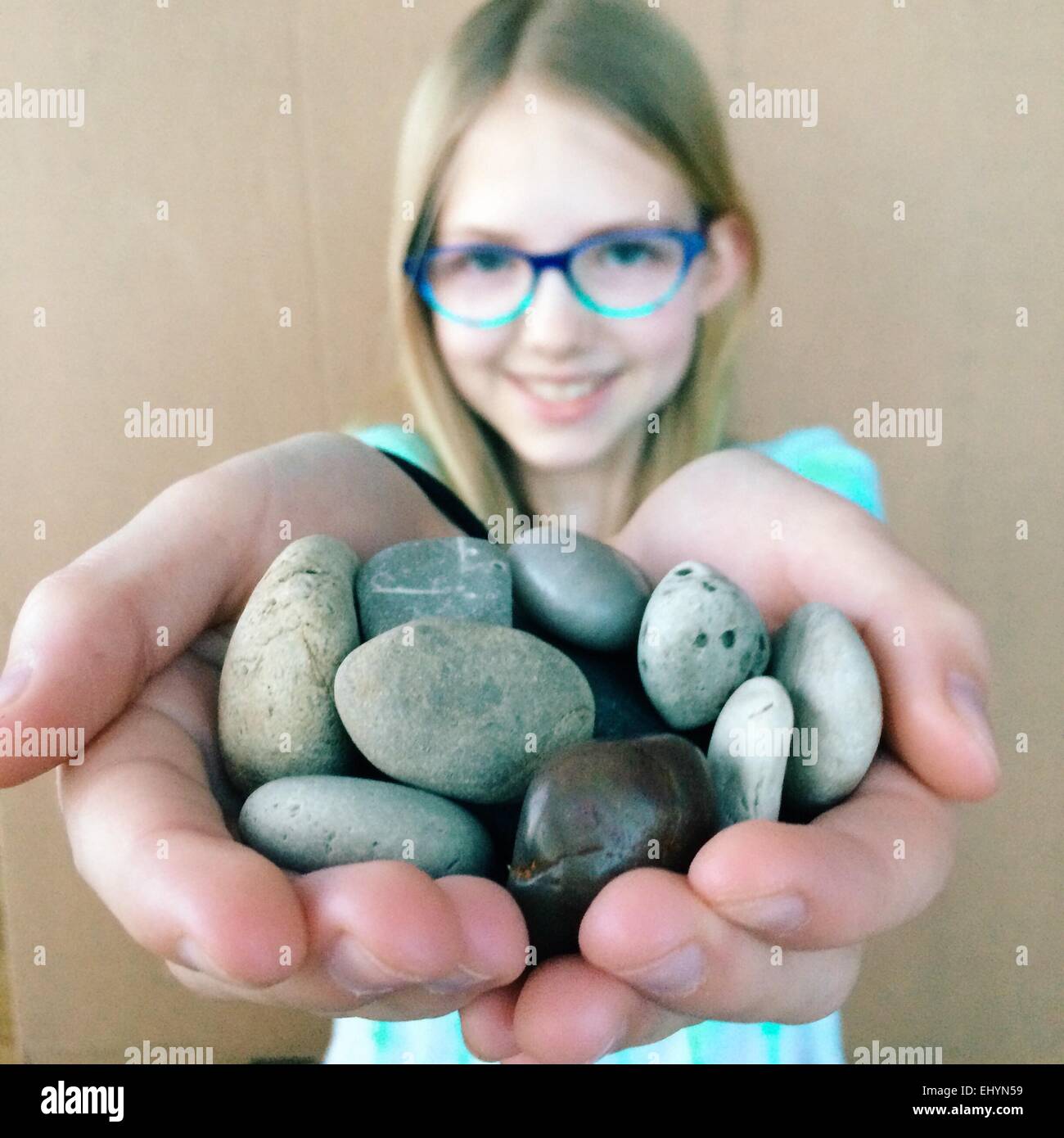 Mädchen hält eine Sammlung von Felsen Stockfoto