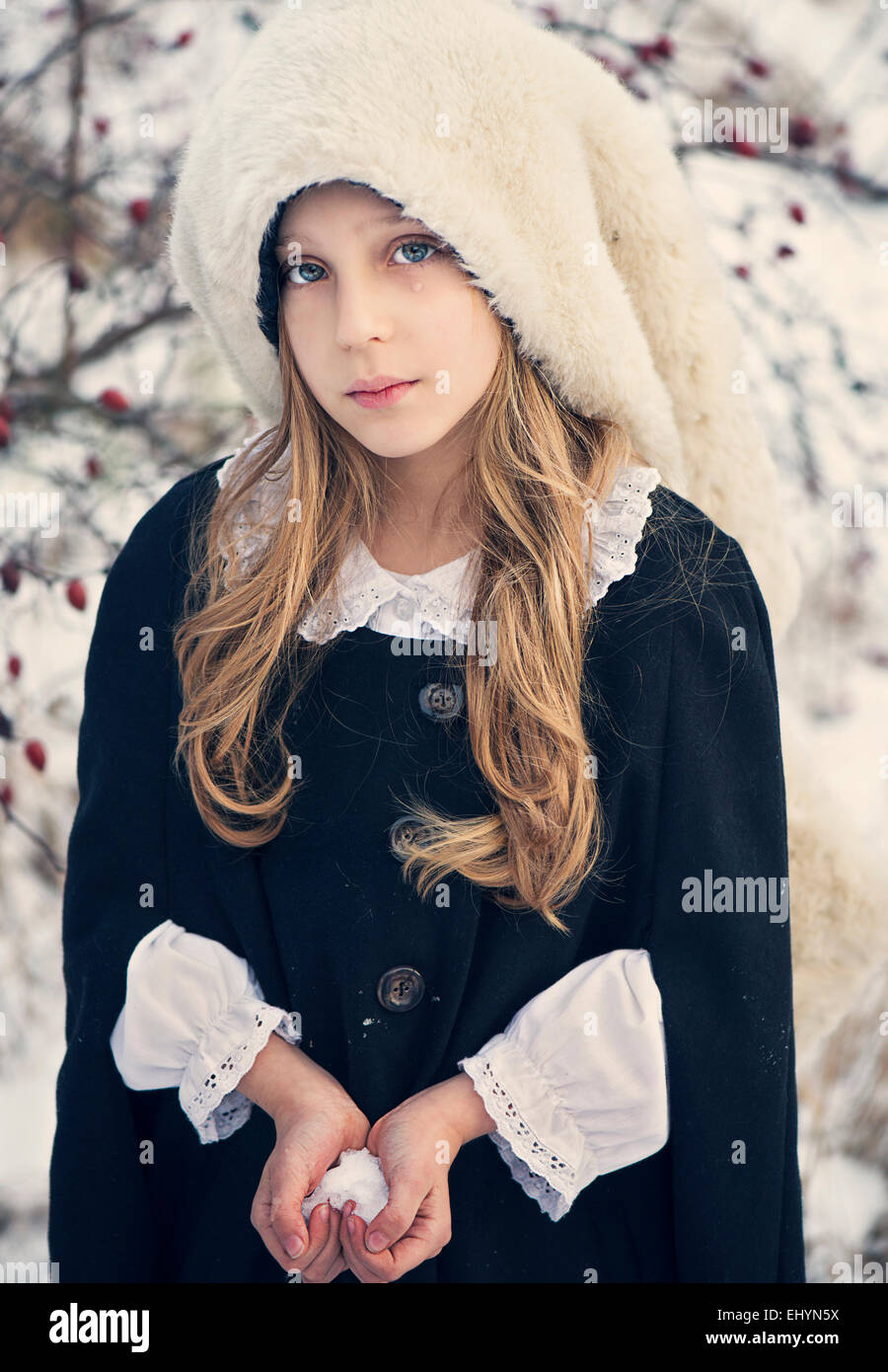 Traurig aussehende Mädchen halten Schnee in der Form eines Herzens Stockfoto