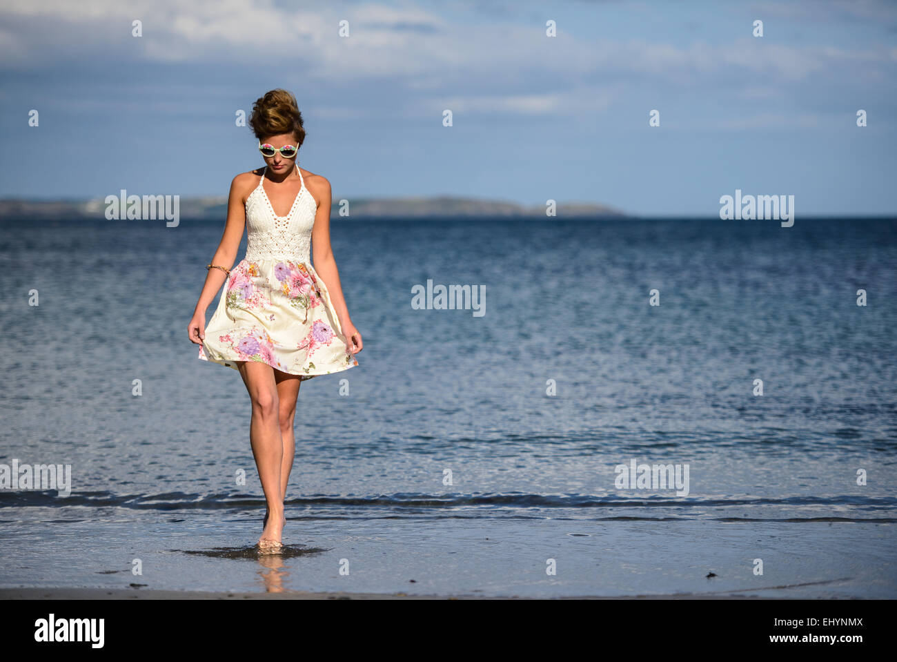 Junge Frau am Strand entlang spazieren Stockfoto