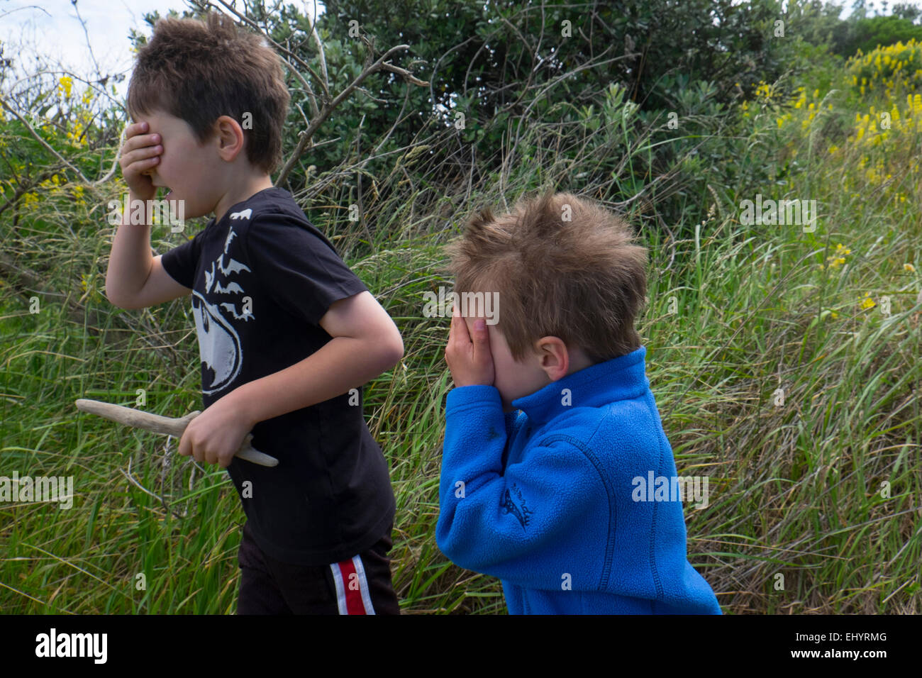 Kinder spielen verstecken und suchen im Feld Stockfoto