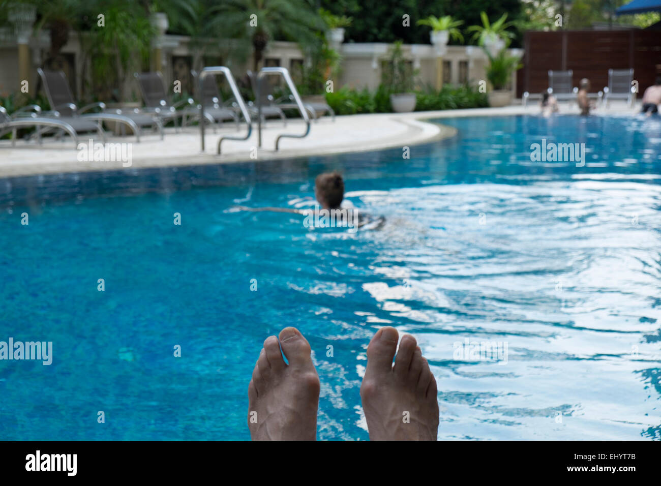 Frau, Schwimmen im Pool mit Füßen zeigen. Stockfoto