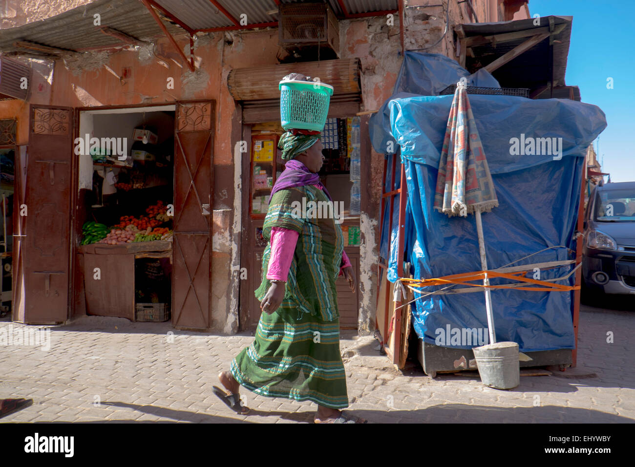 Frau in traditioneller afrikanischer Kleidung Korb auf ihrem Kopf, Medina, alte Stadt, Marrakesch, Marokko, Nordafrika Stockfoto