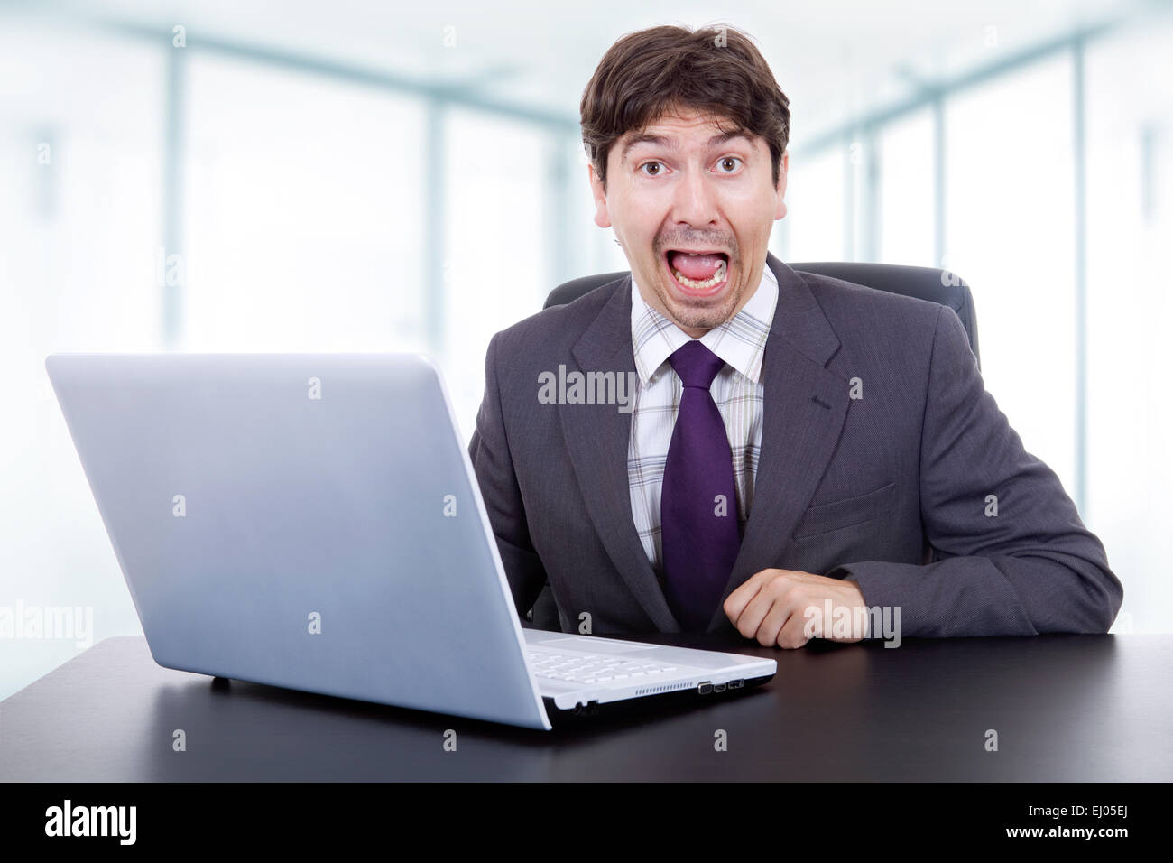 verrückte Geschäftsmann arbeiten mit ist Laptop im Büro Stockfoto