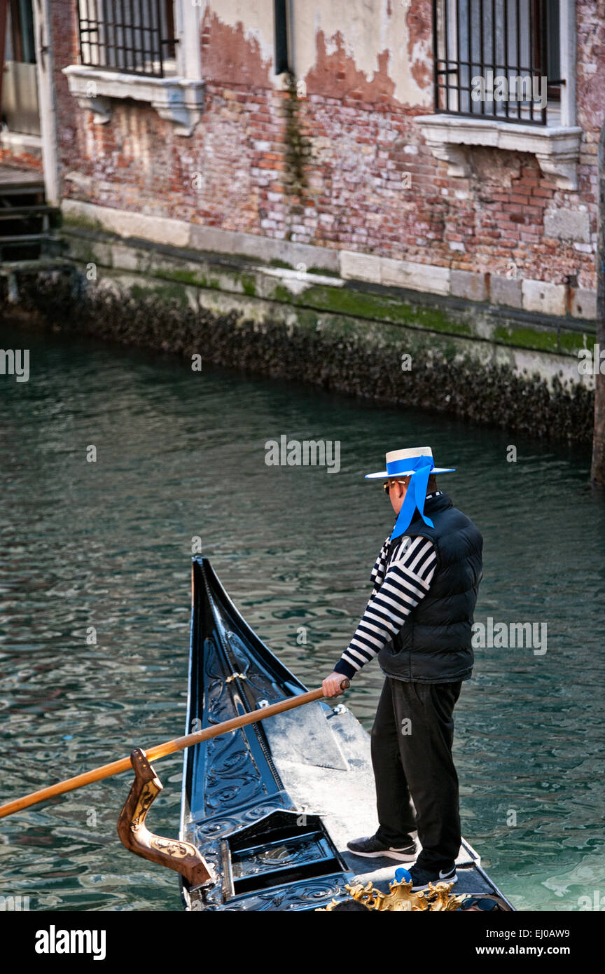 Gondoliere rudert seine Gondel auf einem Kanal. Stockfoto