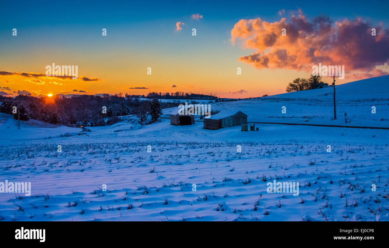 Sonnenuntergang über ein Schneefeld überdachten Hof in ländlichen York County, Pennsylvania. Stockfoto