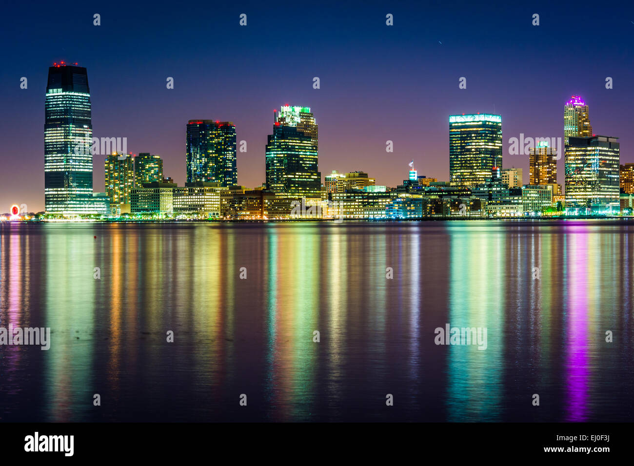 Die Jersey City Skyline bei Nacht, vom Pier 34, Manhattan, New York gesehen. Stockfoto