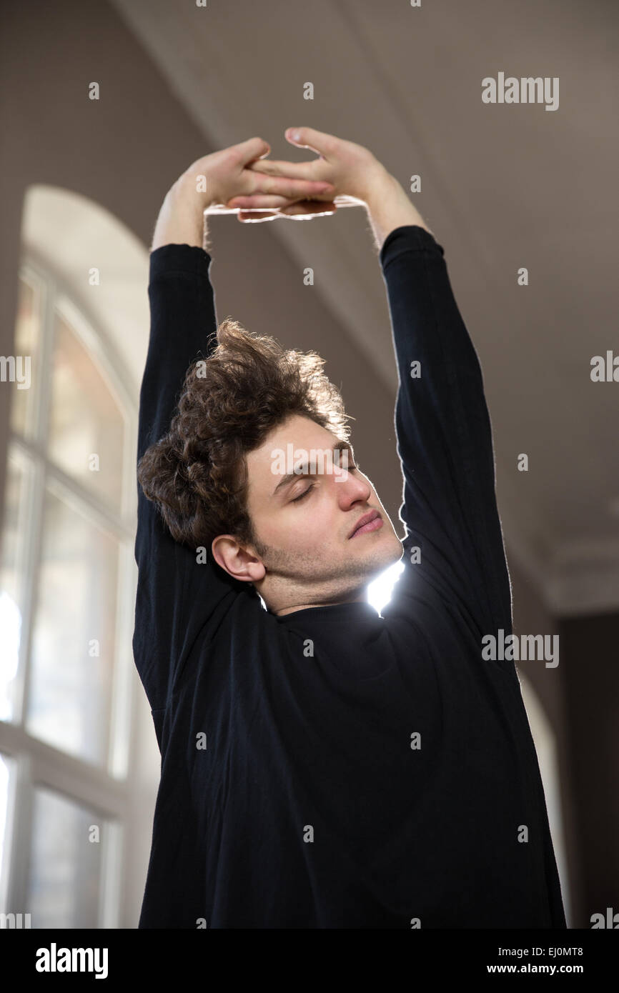 Hübscher junger Mann stretching Hände am gym Stockfoto