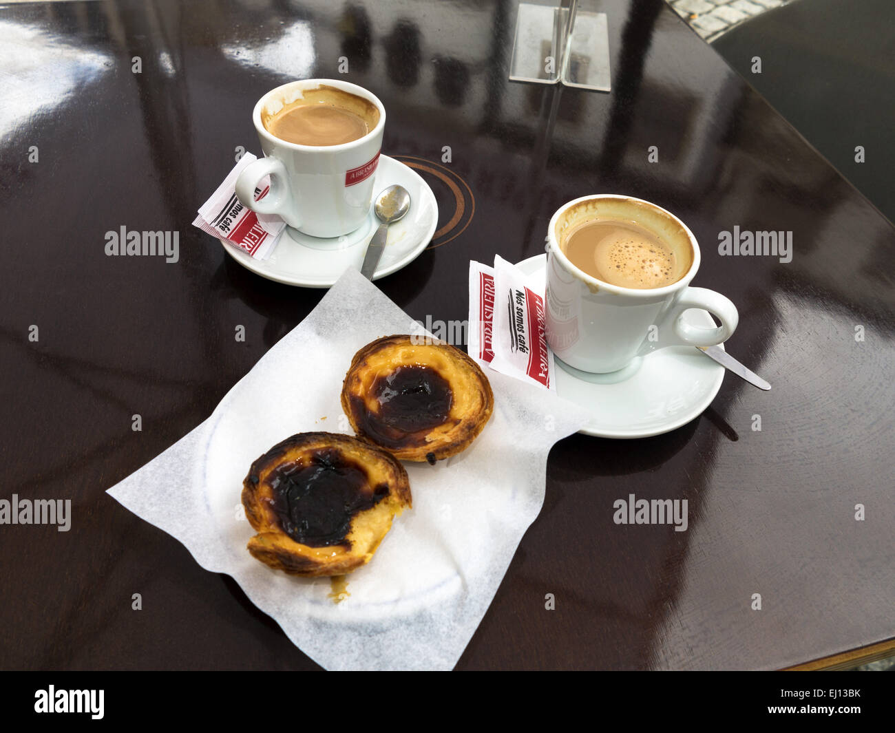 Pastel de Nata Portugiese Ei Torte Teig und zwei Tassen Kaffee auf einem dunklen braunen Tisch Stockfoto