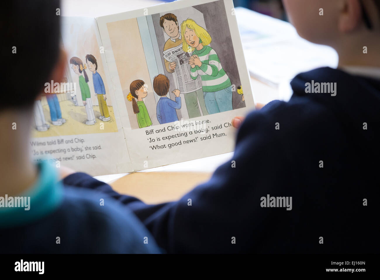 Zwei britische primäre Schuljungen in einer UK-Grundschule lesen lernen Stockfoto