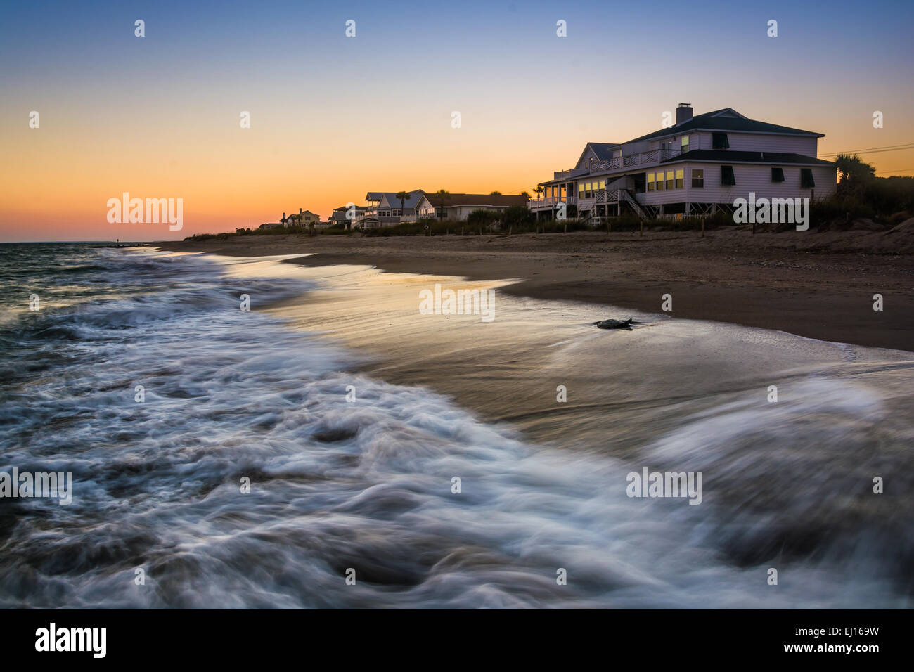 Wellen in den Atlantischen Ozean und am Strand Häuser bei Sonnenuntergang, Edisto Beach, South Carolina. Stockfoto