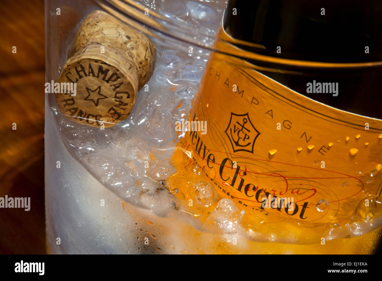 Schließen Sie die Ansicht auf Veuve Clicquot feine Flasche Champagner auf Eis im Weinkühler mit Champagner Korken in stimmungsvolle Beleuchtungssituation Stockfoto