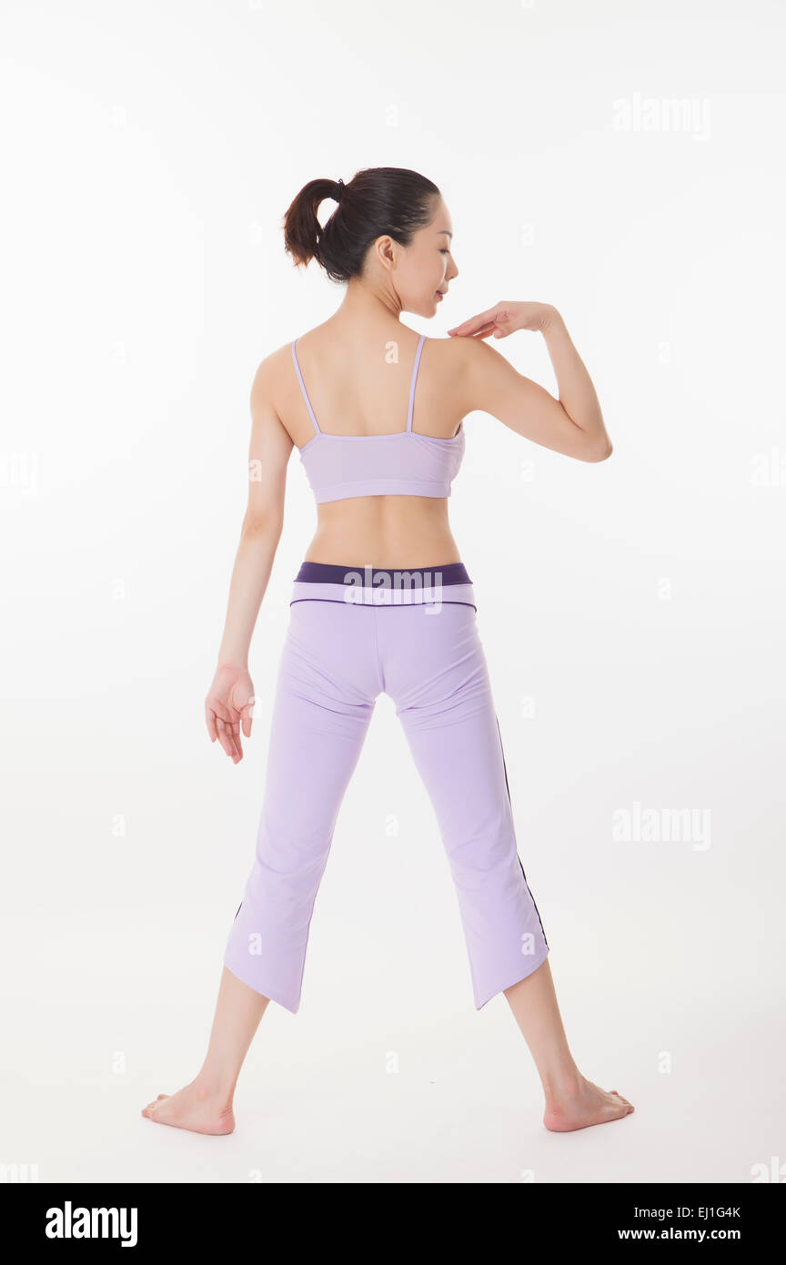 Frau, Yoga zu praktizieren und stehend mit Hand auf Schulter Stockfoto