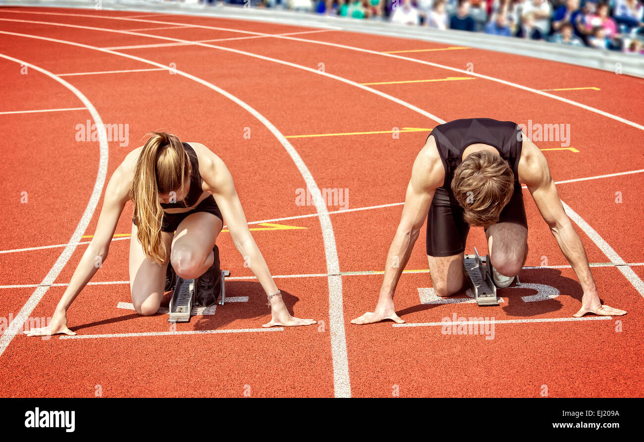Leichtathletik-Foto von wenigen Sprinter kniend in Startposition, in einer Kurve eines Stadions startbereit. Stockfoto