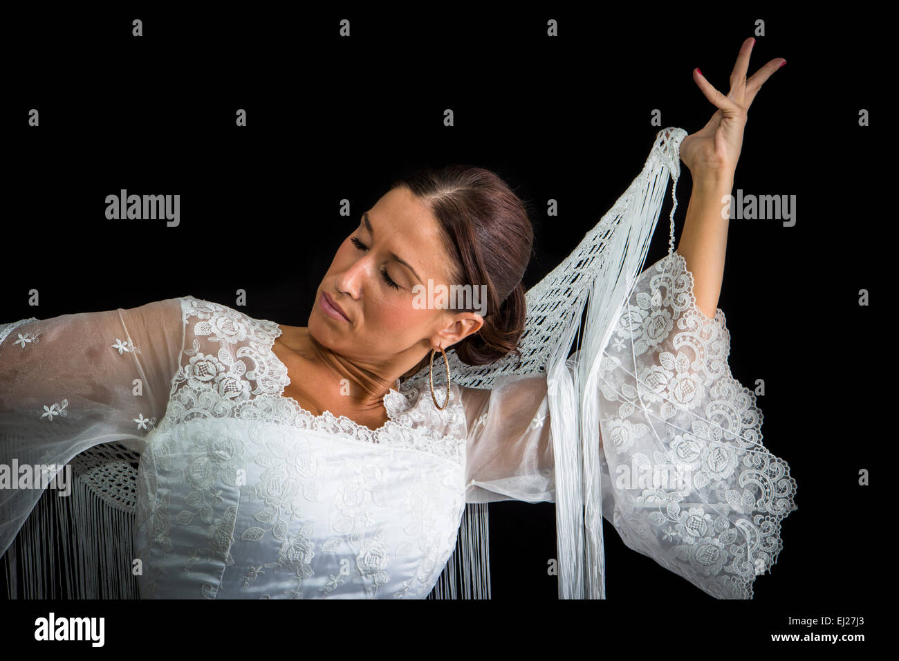 Flamenco-Tänzerin mit weißen Kleid und Hände gekreuzt auf seinem Rücken auf schwarzem Hintergrund Stockfoto