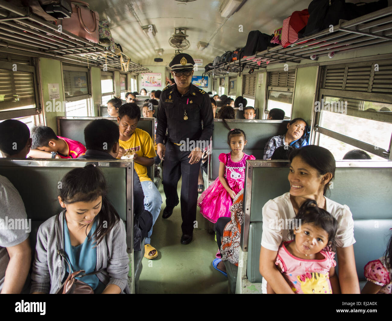 Ayutthaya, Ayutthaya, Thailand. 19. März 2015. Der Dirigent die dritte Klasse Zug von Ayutthaya nach Bangkok Fahrgäste Tickets kontrollieren. Die Bahnlinie von Bangkok nach Ayutthaya war die erste Eisenbahn in Thailand gebaut und wurde im Jahre 1892 eröffnet. Die staatliche Eisenbahn von Thailand (SRT), gegründet 1890, betreibt 4.043 Kilometer Meter Messgerät, das meisten Teilen von Thailand erreicht. Viel von der Strecke und viele der Züge sind in schlechtem Zustand und Züge fahren häufig spät. Unfälle und Pannen sind ebenfalls üblich. Aufeinanderfolgende Regierungen, einschließlich der aktuellen militärischen Regierung haben pr Stockfoto