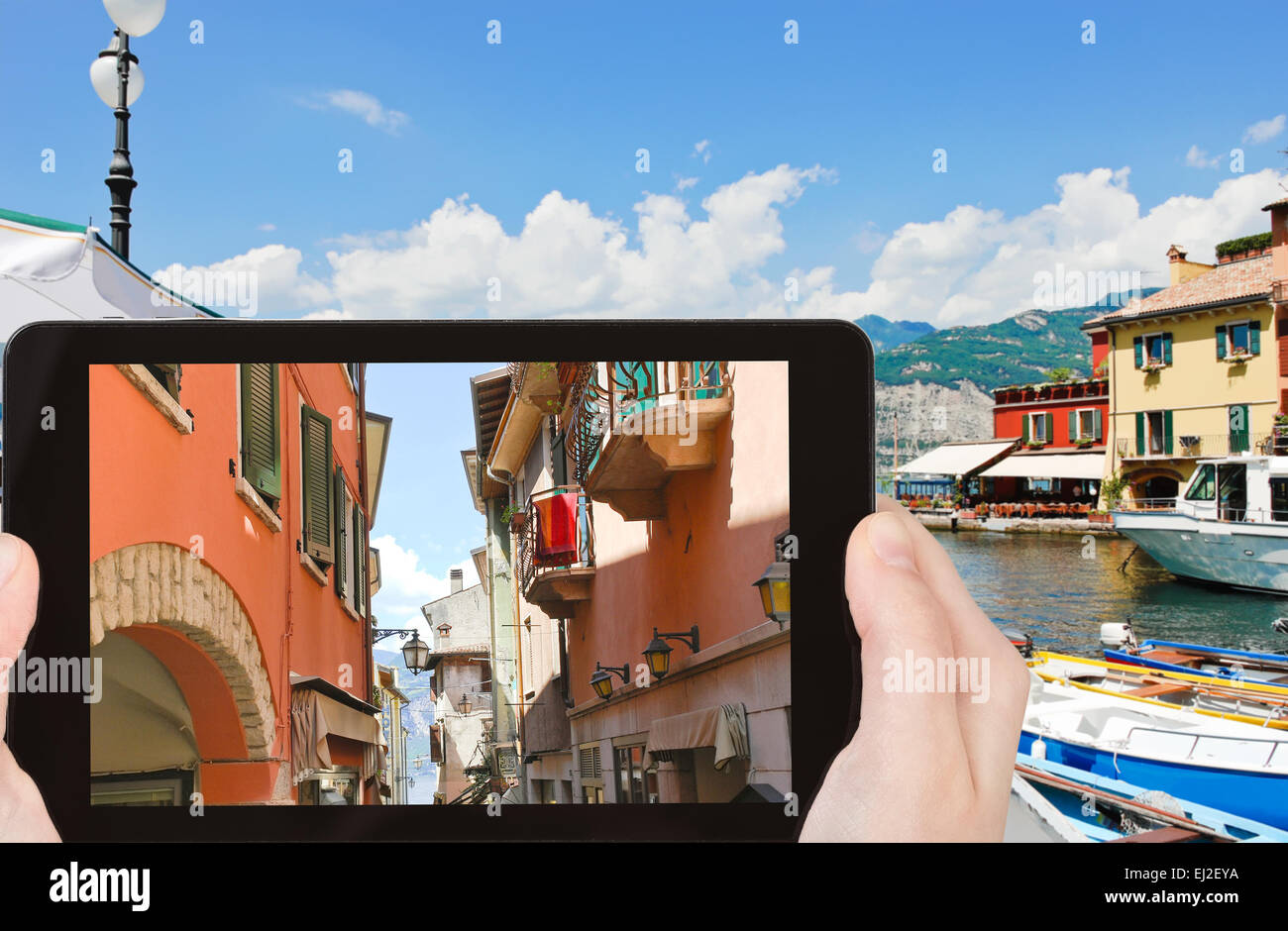 Konzept - Reisen Tourist nimmt Bild der schmalen Straße bis zum Gardasee in Malcesine Stadt, Italien auf Smartphone, Stockfoto