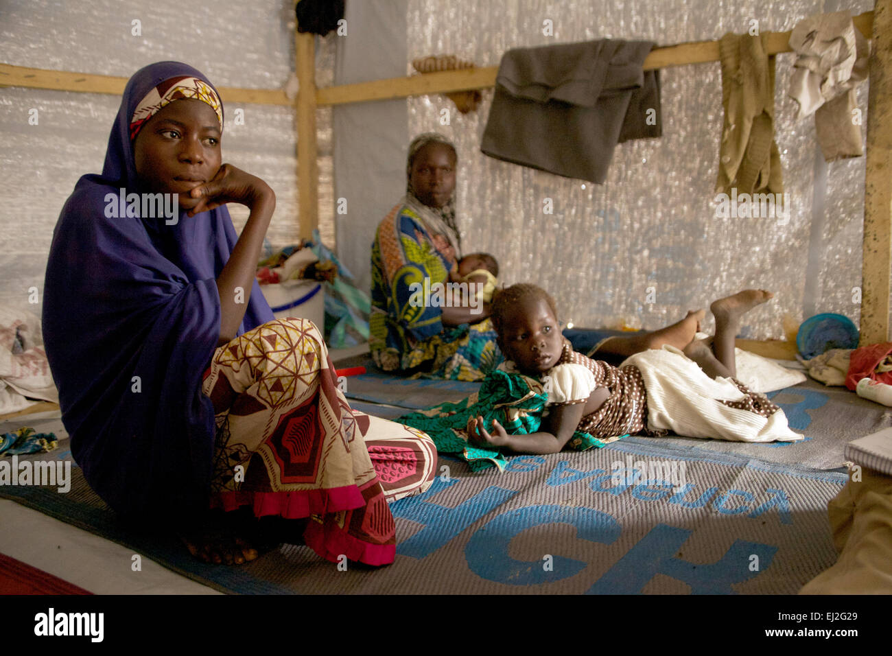 15-jährigen Fatima Abdulhamid (l) und andere Mitglieder ihrer Familie sitzen in ihrem Zelt und in einem Flüchtlingslager in Baga Sola, westlichen Tschad, 4. März 2015. Flüchtlinge aus Nordost-Nigeria floh in den benachbarten Tschad nach einem Angriff durch islamistische Extremisten von Boko Haram auf seine Heimatstadt. Foto: Kristin Palitza/dpa Stockfoto