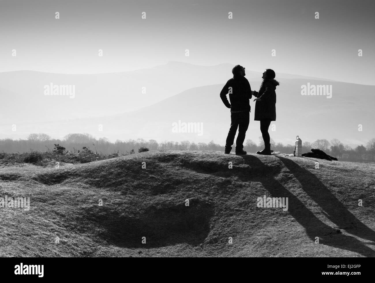 Glückliches Paar in der hellen Frühlingssonne in Brecon Beacons in Wales, das während der Sonnenfinsternis spricht und lacht Stockfoto