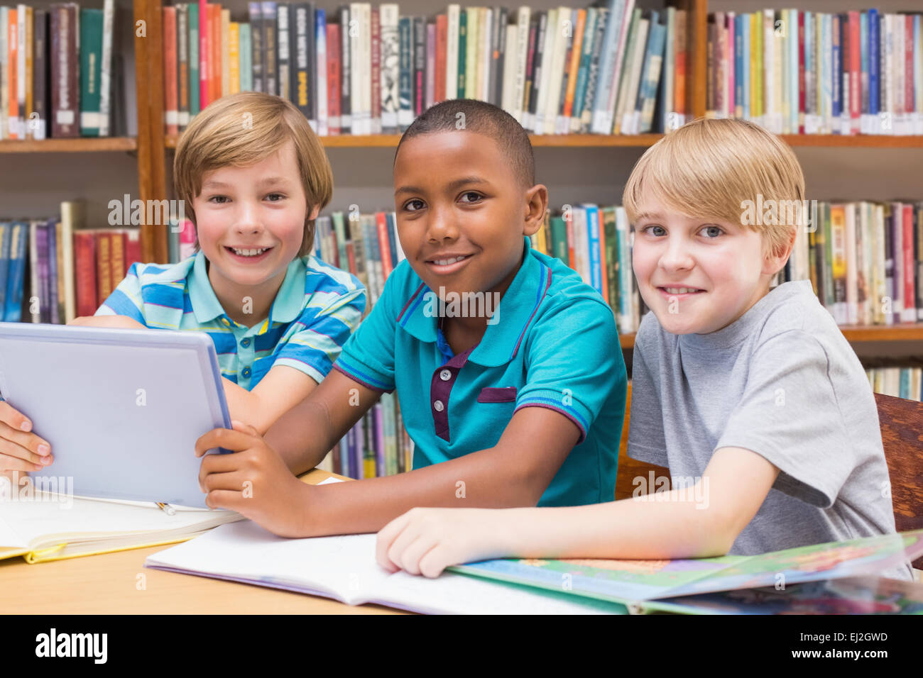 Niedlichen Schülerinnen und Schüler mit Tablet-PC in der Bibliothek Stockfoto