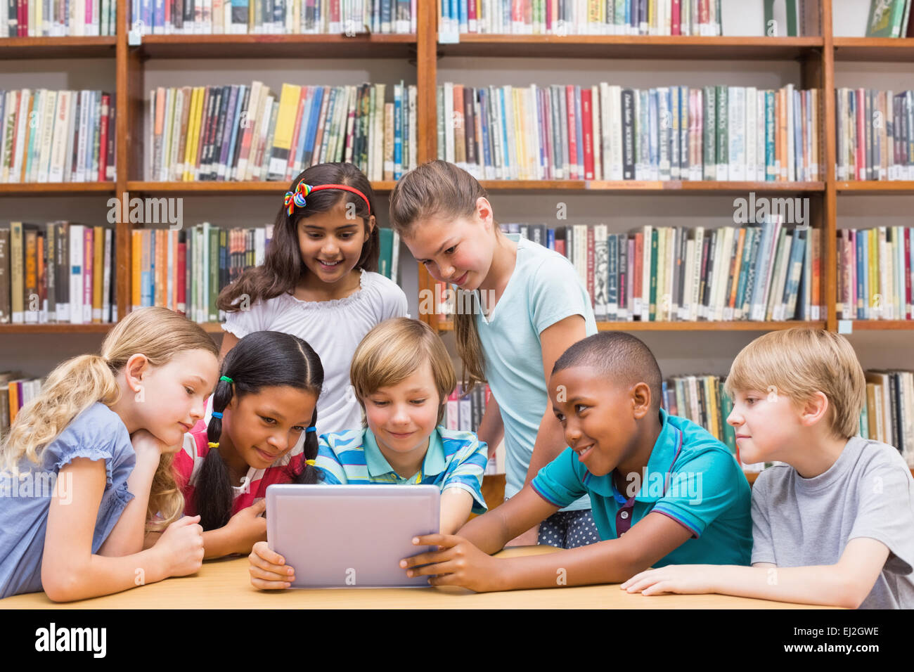 Niedlichen Schülerinnen und Schüler mit Tablet-PC in der Bibliothek Stockfoto