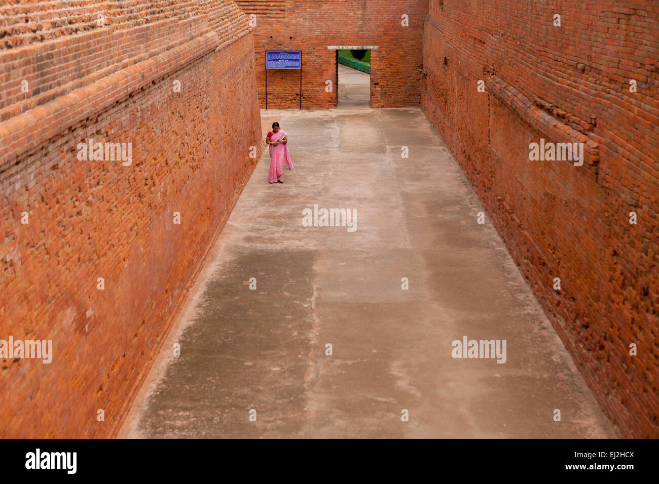 Eine Besucherin geht durch eine Gasse am alten buddhistischen Institutskomplex von Nalanda in Nalanda, Bihar, Indien. Stockfoto