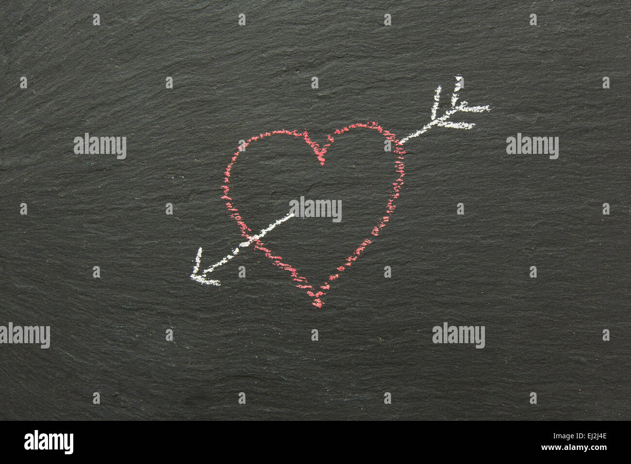 Kreide-Herz mit Pfeil auf einer Tafel gezeichnet... Stockfoto