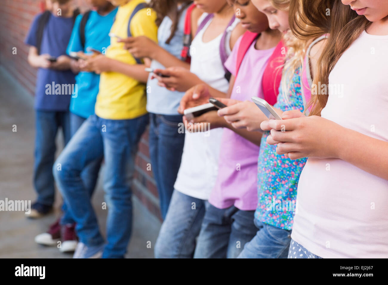 Niedlichen Schülerinnen und Schüler mit Handy Stockfoto