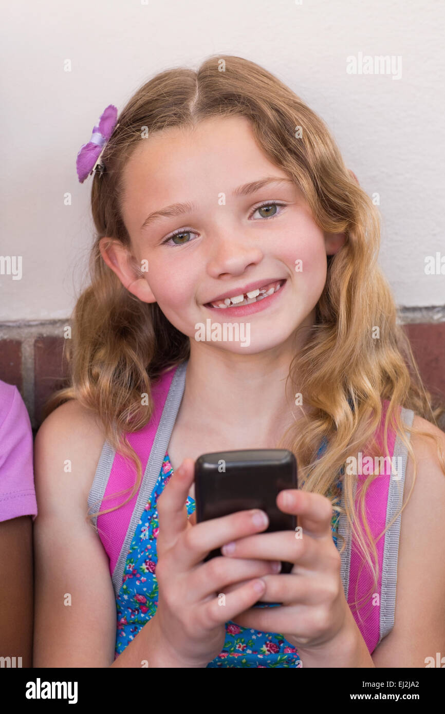 Süße Schülerin mit Handy Stockfoto
