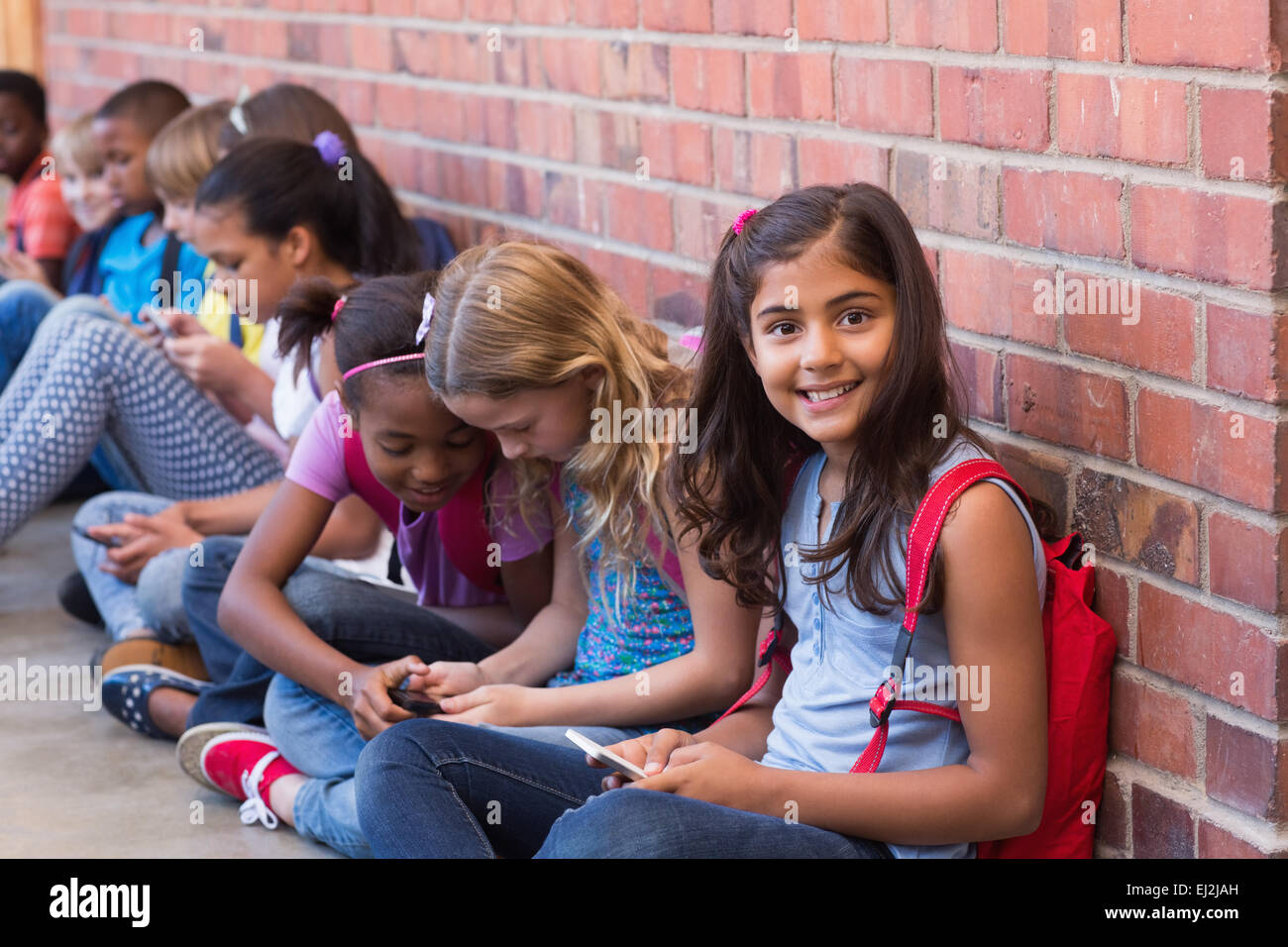 Niedlichen Schülerinnen und Schüler mit Handy Stockfoto