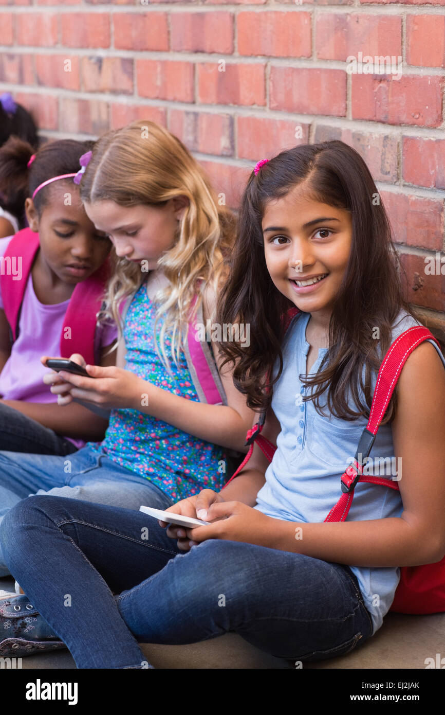 Niedlichen Schülerinnen und Schüler mit Handy Stockfoto