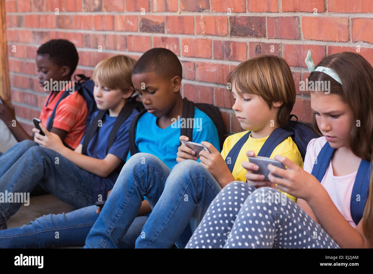 Niedlichen Schülerinnen und Schüler mit Handy Stockfoto