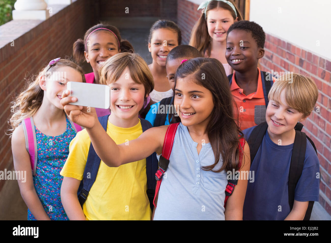 Niedlichen Schülerinnen und Schüler mit Handy Stockfoto
