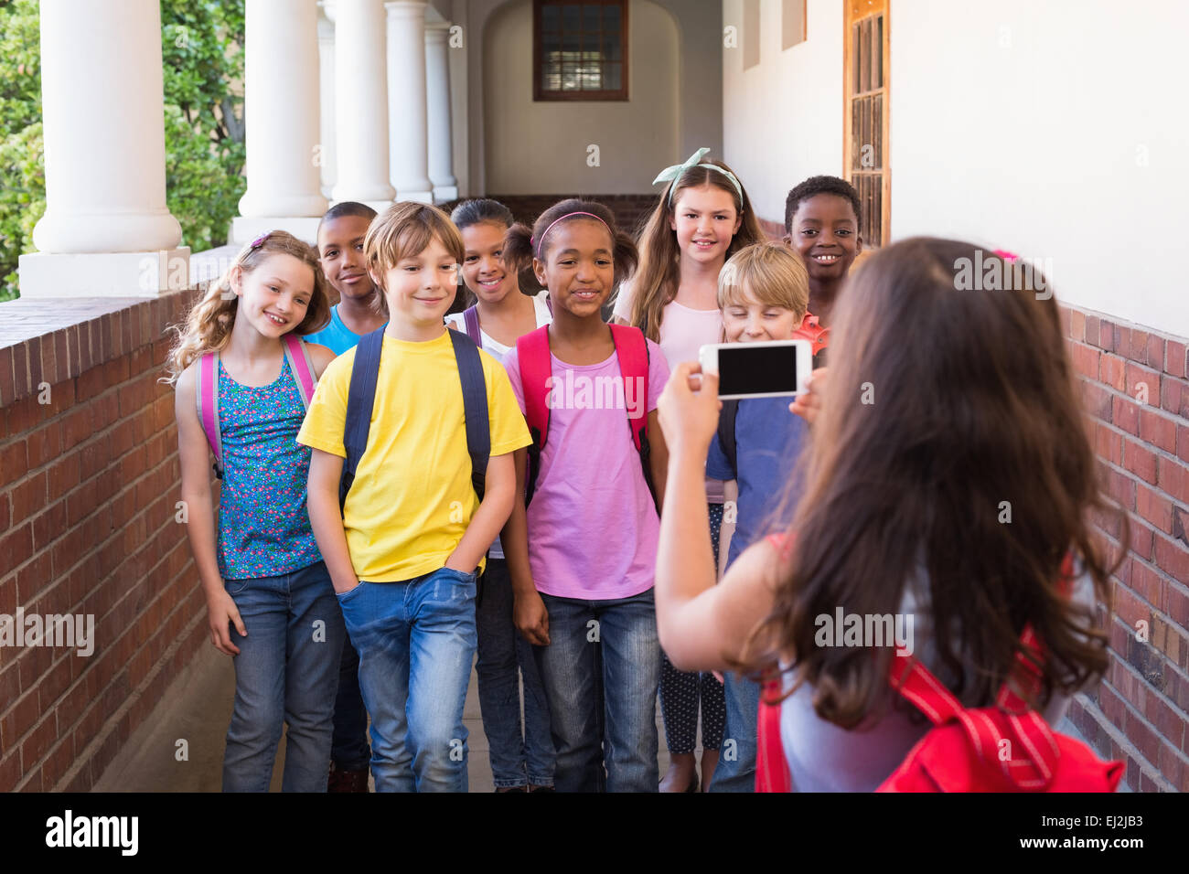 Niedlichen Schülerinnen und Schüler mit Handy Stockfoto