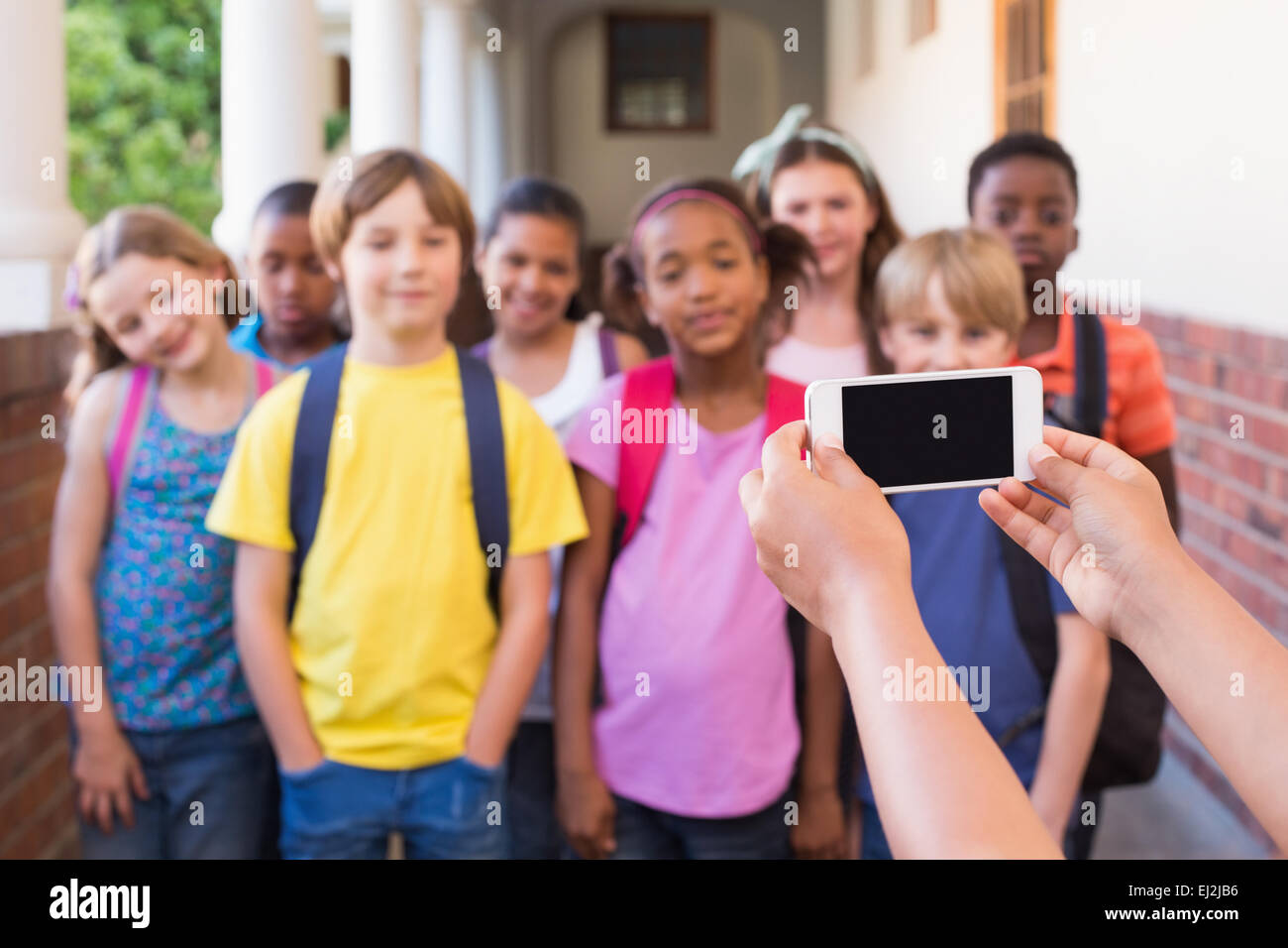 Niedlichen Schülerinnen und Schüler mit Handy Stockfoto