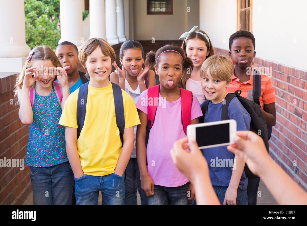 Niedlichen Schülerinnen und Schüler mit Handy Stockfoto
